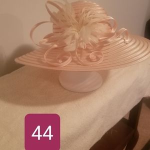 Soft pink, wide-brimmed hat w/ satin ribbon and cream flowers.